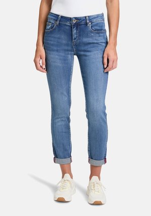 Blå denim jeans med slim fit, mellemhøj talje og oprullede ærmer, der afslører et ternet mønster. Blød tekstur med let slidager.