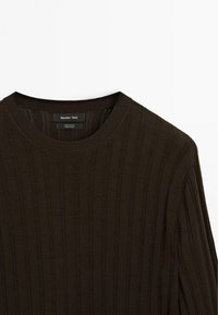 Mörkbrun bomullströja med ribbad textur och rundad halsringning. Har en etikett med "Massimo Dutti"-märket inuti kragen.