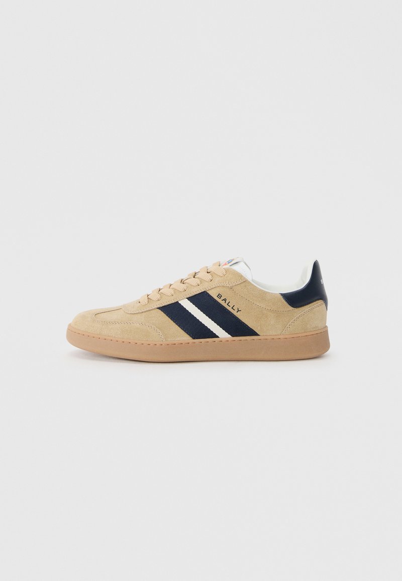 Zapatillas de ante beige con rayas marinas y blancas, puntera redonda y suela de goma marrón. Cuentan con cierre con cordones y detalle de marca en el lateral.