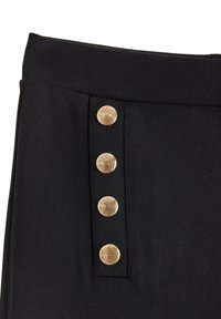 Černý oděv s hladkou texturou, zdobený čtyřmi bohatě zdobenými zlatými knoflíky na boku, což vytváří strukturovaný design.
