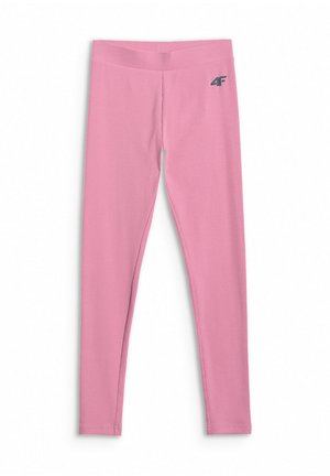 Dziewczyna z długimi ciemnymi włosami ma na sobie różowy, gradientowy, oversize'owy t-shirt, różowe legginsy, białe skarpetki, białe sneakersy oraz jasnoróżową bluzę wiązaną w pasie.