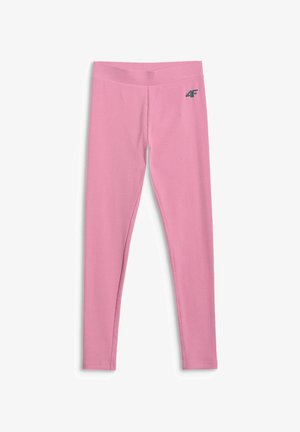 Dziewczyna z długimi ciemnymi włosami ma na sobie różowy, gradientowy, oversize'owy t-shirt, różowe legginsy, białe skarpetki, białe sneakersy oraz jasnoróżową bluzę wiązaną w pasie.