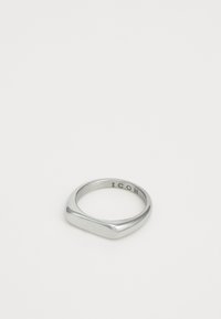 Silver signet ring with a flat top and the word "ICON" engraved on the inner band, set against a plain white background.