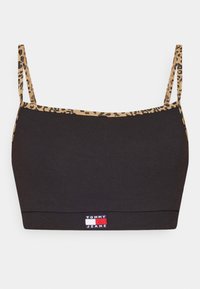 Crop top noir avec de fines bretelles et une bordure imprimé léopard, doté d'une petite étiquette logo Tommy Jeans au centre en bas.