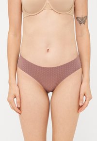 Katoenen bikini in zacht mauve met een geometrische textuur, laag uitgesneden ontwerp en gladde randen, met minimale stiksels en zonder zichtbare bevestigingen.