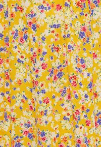 Tecido floral com um fundo amarelo brilhante, apresentando pequenos aglomerados de flores vermelhas, cor-de-rosa, azuis e brancas por toda a parte.