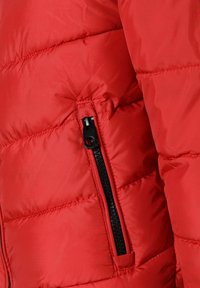 Giacca imbottita rossa con tasca con zip, texture trapuntata e materiale leggero con finitura lucida.