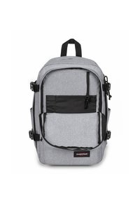 Zaino grigio con superficie texturizzata, tasca con zip nera, spallacci regolabili e fibbie, con logo sul davanti.
