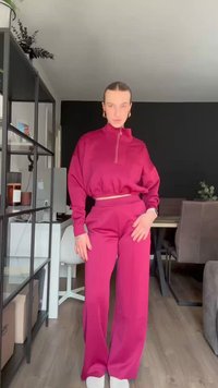 Maroon two-piece activewear set featuring a cropped pullover with a high collar and long sleeves, paired with wide-leg pants. Soft texture.