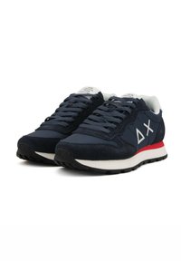 Marineblaue Sportschuhe aus Wildleder und Mesh-Materialien. Ausgestattet mit einem weißen Logo und einem roten Akzent auf der Sohle. Schnürdesign und profilierte Gummisohle.