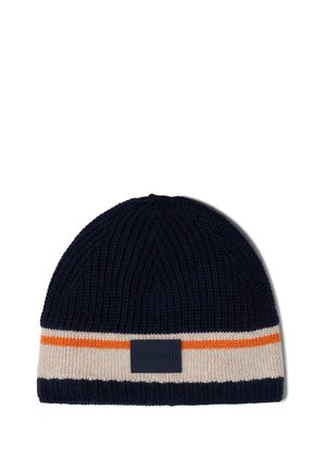 Strikket hue i marineblå med en cremefarvet og orange stribe ved kanten. Har et struktureret stof og et rektangulært mærke.