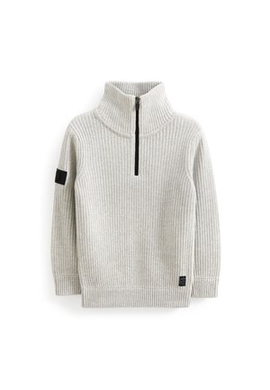 Lysegrå ribstrikket pullover med høj krave og kort sort lynlås foran, med sort patch på venstre ærme og label i bundkanten.