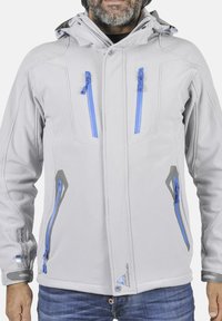 Veste gris clair avec poches zippées bleues, accents gris et capuche. Fabriquée à partir d'un matériau lisse et extensible, elle présente des détails de couture visibles.