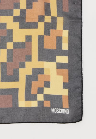 Μεταξωτό μαντίλι με αφηρημένο γεωμετρικό μοτίβο σε αποχρώσεις του γκρι, κίτρινου και καφέ, με μαύρο περίγραμμα και λογότυπο "MOSCHINO" στο κάτω μέρος.