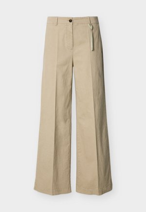 Pantalon beige à jambes larges avec pli frontal, passants pour ceinture, fermeture par bouton et une petite étiquette en tissu sur le côté droit de la ceinture.