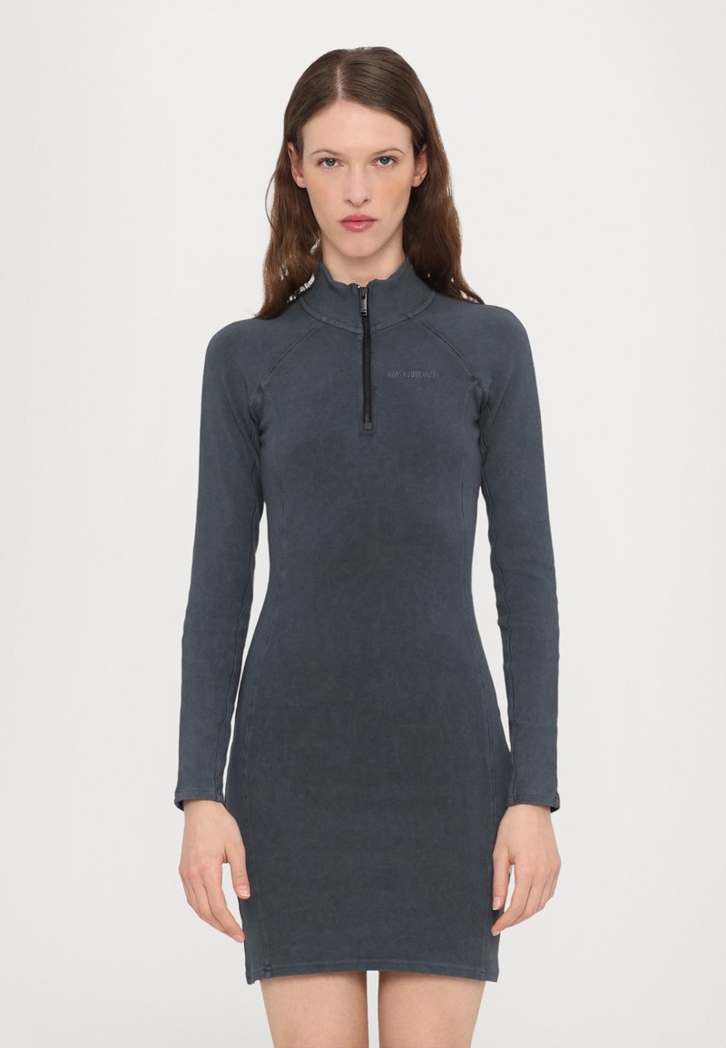 Rochie cu mâneci lungi, de culoare gri închis, cu un guler înalt și închidere cu fermoar. Fabricată dintr-un material fin, cu o siluetă ajustată și cusături contrastante.