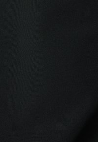 Tejido negro con una textura suave y un sutil patrón acanalado, diseñado para versatilidad y comodidad en diversas aplicaciones.