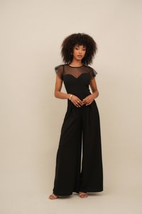 Black jumpsuit featuring a fitted bodice with a sweetheart neckline, tulle shoulder accents, and wide, flowing pant legs.