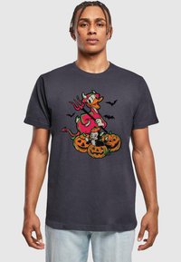 Graues Baumwoll-T-Shirt mit einem bunten Halloween-Motiv, das Kürbisse, eine Katze und eine Figur im Teufelskostüm zeigt.