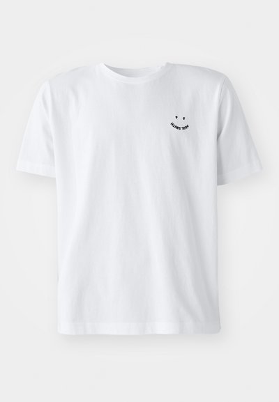 Λευκό μπλουζάκι κοντό μανίκι από βαμβάκι, με μικρή μαύρη απεικόνιση χαμογελαστού προσώπου και κείμενο στην αριστερή πλευρά του στήθους.