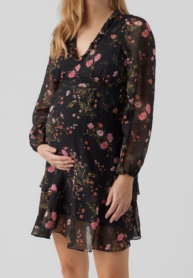 Raskausmekko mustasta läpinäkyvästä kankaasta, jossa on monivärinen kukkakuosi, syvä v-pääntie, pitkät puffihihat ja kerroksellinen röyhelöhelma.