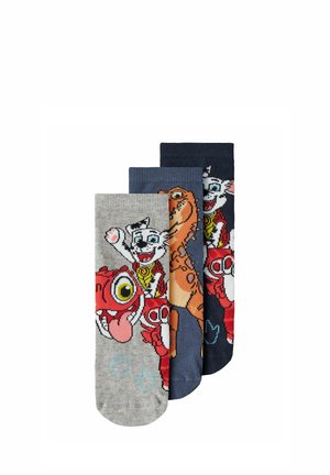 Trois chaussettes colorées pour enfants avec des personnages de dinosaure et de chien en rouge, orange, gris, bleu et marine.