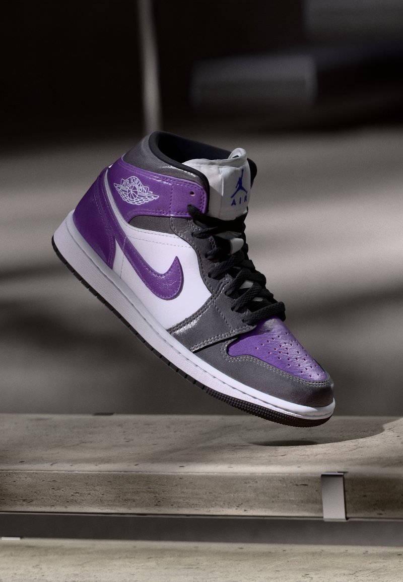 Wysokie sneakersy z połączeniem fioletowej, szarej i białej skóry. Teksturowane akcenty i czarna podeszwa. Widoczne logo Nike Air.