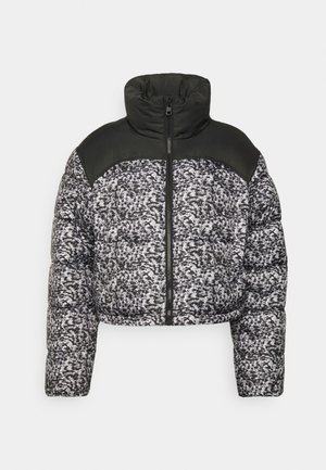 Avskuren pufferjacka med svart krage och axelpanel, med ett svart och vitt prickigt mönster på kroppen och dragkedjestängning.