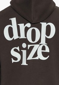 Brauner Hoodie mit fettem, weißen Schriftzug "drop size", großer Kapuze und einem weichen, strukturierten Stoff.