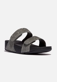 Zwarte sandalen met twee sprankelende grijze banden, met een getextureerde voetbed en een wigzool voor extra hoogte. Verstelbare klittenbandsluitingen.
