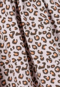 Leopardenmusterstoff mit dunkelbraunen Flecken und orangefarbenen Akzenten auf einem hellrosa Hintergrund, der eine weiche, strukturierte Oberfläche zeigt.