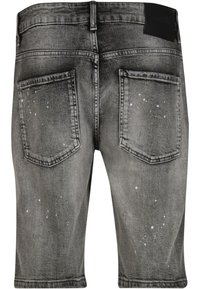 Grå denimshorts med to baglommer og subtile hvide malingstænk på stoffet, vist bagfra.