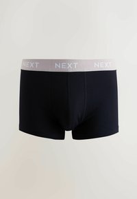 Boxers noirs avec une ceinture élastique douce et gris clair portant le nom de la marque "NEXT" en blanc. Le matériau semble lisse et extensible.