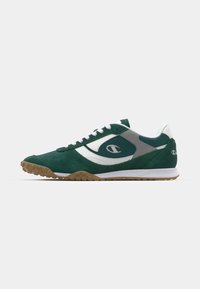 Încălțăminte sport verde din suede cu accente albe, bot rotund, guler căptușit și talpă exterioară din cauciuc texturat. Prezintă logo pe lateral.