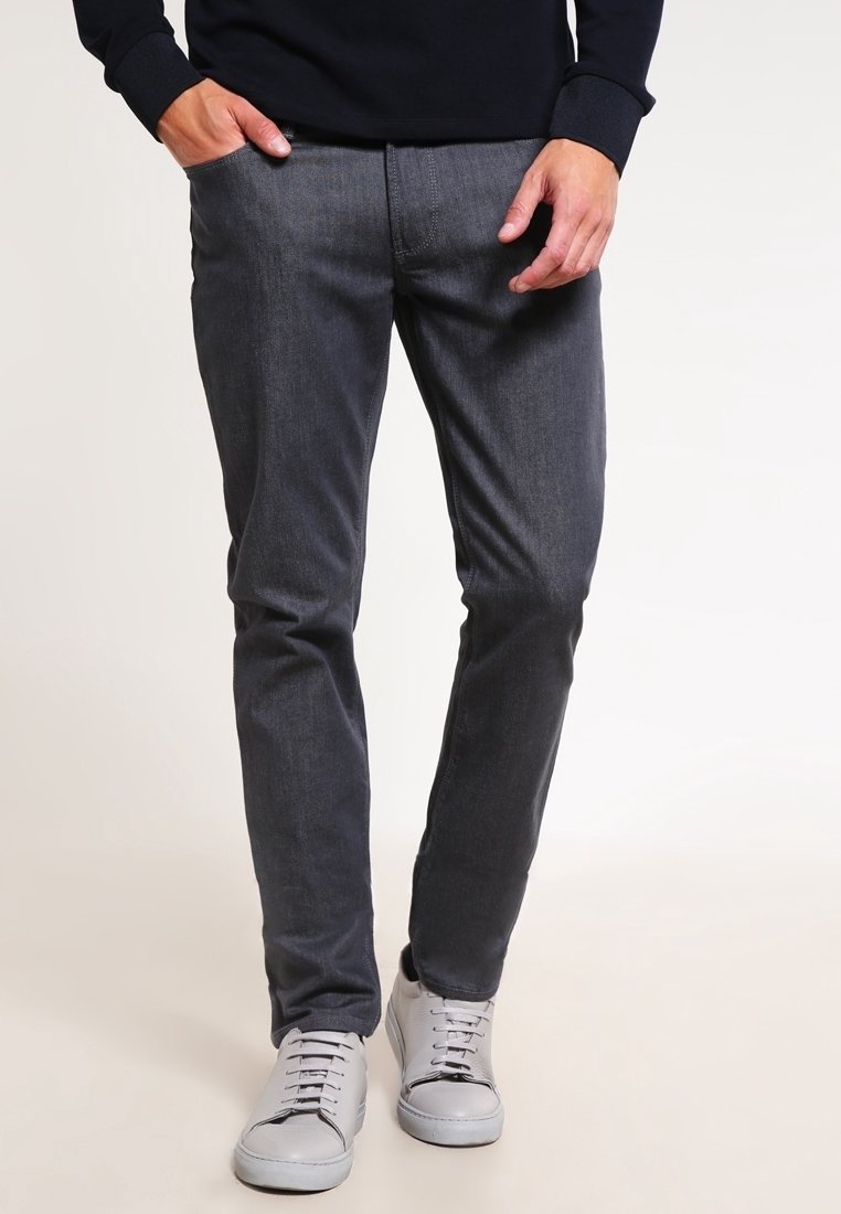 Grå denimbyxor med slim fit, med en jämn yta och rena linjer, parat med ljusgrå sneakers.