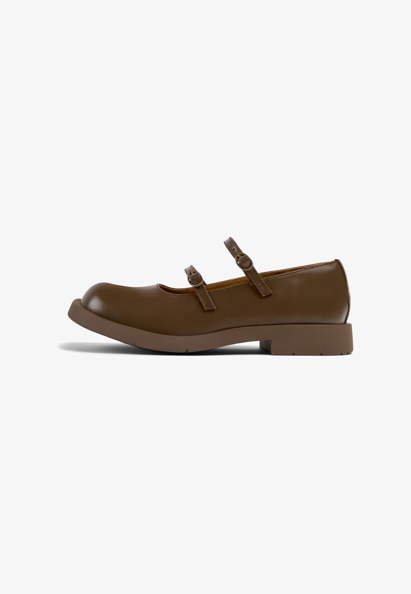 Chaussures Mary Jane marron avec un bout rond, deux sangles réglables et un petit talon carré. Fabriquées en matériau synthétique lisse.
