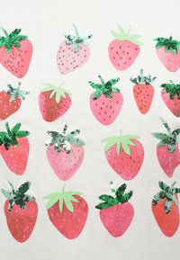 Βαμβακερό πουκάμισο με επαναλαμβανόμενο σχέδιο ροζ φραουλών με πράσινες λεπτομέρειες και παγιέτες στις κορυφές, σε ανοιχτό γκρι φόντο.