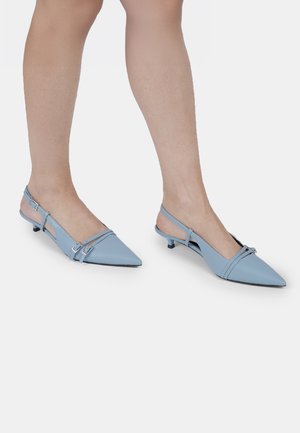 Vaaleansinisiä, kärjestään teräviä slingback-kenkiä, jotka on valmistettu sileästä nahasta. Kengissä on matala kitten-korko ja kaksi säädettävää remmiä metallikoristeilla.