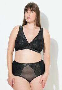 Czarny komplet bielizny składający się z przezroczystego koronkowego biustonosza w kształcie V z szerokimi ramiączkami, dopasowany z wysokim stanem majtek z koronkowymi detalami.