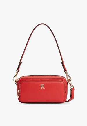 Rød læder skuldertaske med guldfarvet hardware, lynlåslomme foran og aftagelig rem med en lille metal logo på frontpanelet.