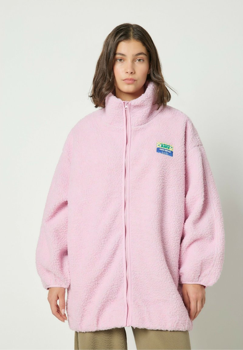 Roosa fliistekootud jakk kõrge kraega, täispikk lukuga ja elastsete mansettidega. Vasakul pool on värviline applikaat, kus on kirjas "ARMY".