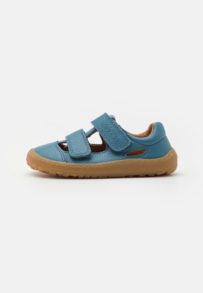 Chaussure pour enfant en cuir bleu avec deux brides velcro réglables et une semelle en caoutchouc beige, sur fond blanc.
