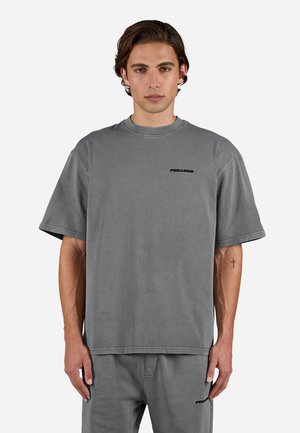 Gray cotton t-shirt with short sleeves, crew neck, and a minimalist black logo on the left chest. The fabric has a smooth texture.