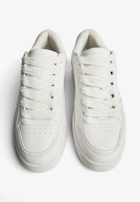 Adidași albi cu șireturi, realizați din piele netedă, cu vârf rotund, guler căptușit, secțiuni perforate și sireturi texturate.