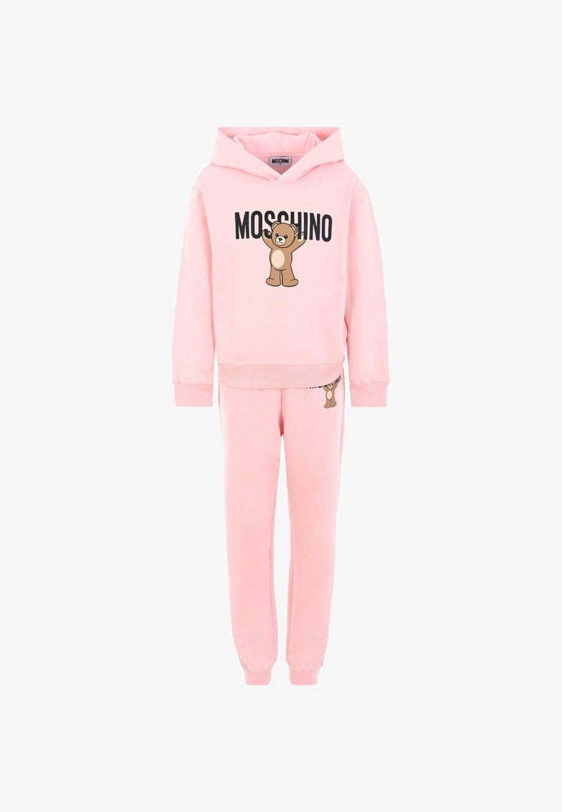 Różowy zestaw bluz i spodni dresowych wykonany z miękkiego materiału. Bluza z kapturem z grafiką niedźwiedzia oraz czarnym napisem "MOSCHINO". Elastyczne mankiety.