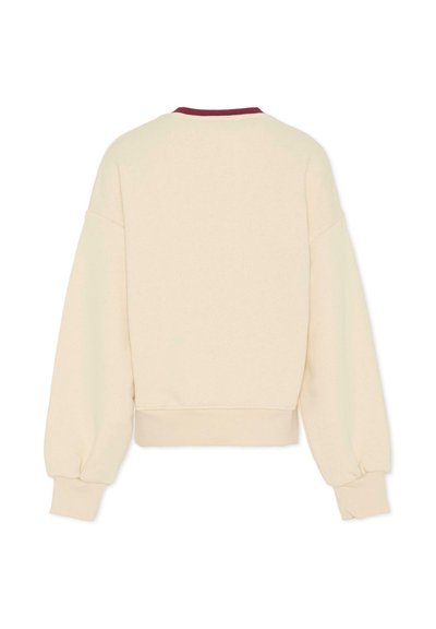 Sweatshirt couleur crème avec un col rond et des accents bordeaux, doté de larges manches ballons et d'une taille côtelée.