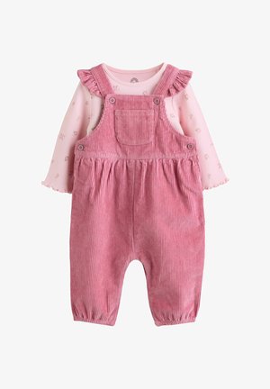 Peto de pana rosa con tirantes fruncidos sobre una camisa floral de manga larga en rosa claro para bebé o niño pequeño.