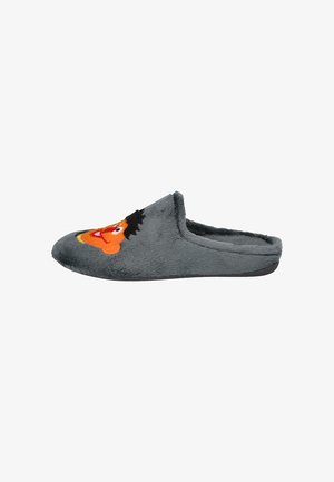 Zapatilla de felpa gris con una textura suave, que presenta un rostro de personaje bordado en naranja y negro en la parte delantera superior. Diseño de cierre trasero.