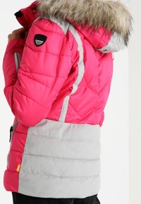 Pink puffer jacket with a grey lower section and faux fur-lined hood. Features quilted design and logo patch on the shoulder. Zipper pockets.