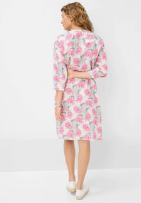 Abito floreale in tonalità di rosa e blu con una vestibilità ampia. Maniche a tre quarti e design fino al ginocchio. Realizzato in tessuto leggero.